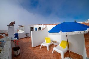 un patio con 2 sillas y una sombrilla en By the sea in the center @ Ericeira, en Ericeira