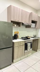 a kitchen with a stainless steel refrigerator and a stove at Executive Apartment, Rosebank , Johannesburg in Johannesburg
