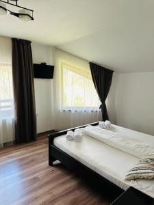 a bedroom with a large bed with towels on it at Casa Valea Cernei in Isverna