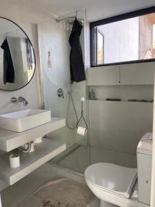 a bathroom with a sink and a toilet and a mirror at A House with A View in Plomari +36 photos