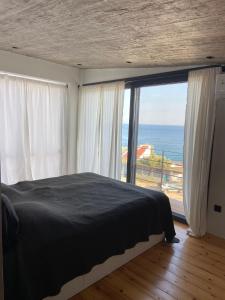 a bedroom with a bed and a large window at A House with A View in Plomari