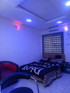 una camera con un letto e una sedia di Annabelle & Annabelle Apartment ad Abeokuta