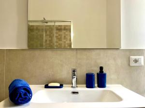 un lavandino in bagno con specchio e asciugamano blu di The seaside villa - Anzio ad Anzio Altre 11 foto