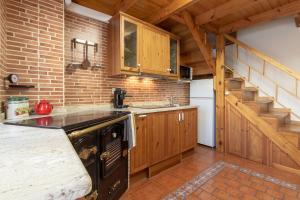 a kitchen with wooden cabinets and a black stove at AH El Escondite de Campomanes VV3485AS in Campomanes