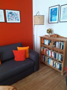 sala de estar con sofá y estantería con libros en Fewo Muschel incl Kurkarte Parkplatz und strandnah, en Ahrenshoop