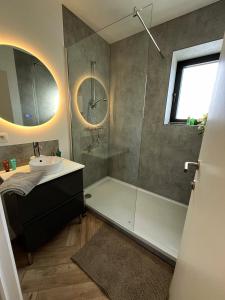 デ・パンネにあるVakantiehuis Zeevonkの浴槽、洗面台、シャワーを備えたバスルーム
