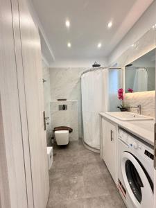 a white bathroom with a toilet and a sink at Infinity Blue Suite in Panteli +88 photos