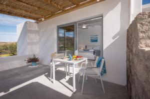 a white table and chairs on a patio with a window at Sarantis Suites & Apartments in Provatas +71 photos