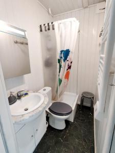 a white bathroom with a toilet and a sink at Le petit cocon au bord de mer in Mers-les-Bains