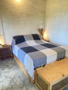 a bedroom with a bed and a wooden table at FAZENDA BOSQUE DAs PALMEIRAS in Itamaracá