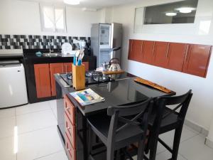 a kitchen with a black counter and two chairs at The Tree House in Philipsburg