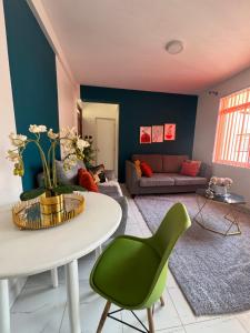 a living room with a white table and green chairs at Glenn 2 in Kiambu