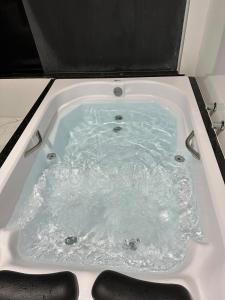a bath tub filled with water in a bathroom at Casa de campo à 10 minutos de São Lourenco mg in Sylvestre Ferraz