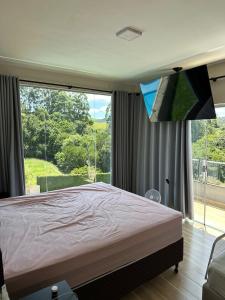 a bedroom with a bed and a large window at Casa de campo à 10 minutos de São Lourenco mg in Sylvestre Ferraz +44 photos