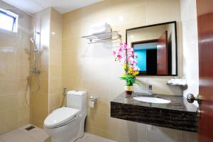 a bathroom with a toilet and a sink and a mirror at Hallmark View Hotel in Melaka