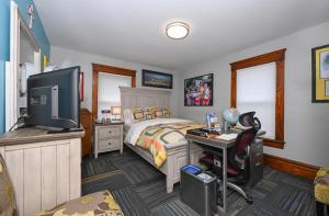 a bedroom with a bed and a desk with a computer at Berrodin Bed & Breakfast in Akron