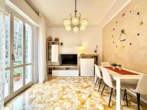 a dining room with a table and chairs and a television at La casa di Nani e Cin in Finale Ligure