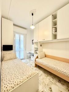 a bedroom with two beds and a desk at La casa di Nani e Cin in Finale Ligure