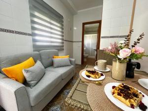 a living room with a couch and a table with food on it at Apartamentos Los Mellizos in Conil de la Frontera