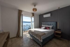 una camera con un grande letto e un balcone di Boka Bay Residences a Herceg-Novi