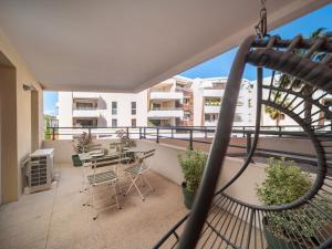 Un balcón de un apartamento con mesa y sillas en Aqaba, en La Ciotat