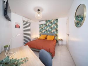 Un dormitorio con una cama, una mesa y un espejo. en Aqaba, en La Ciotat