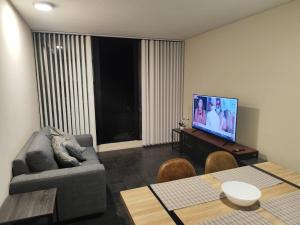 a living room with a couch and a flat screen tv at Apartamento en Concepción con estacionamiento privado in Concepción