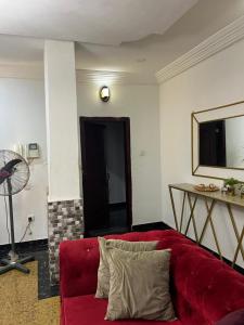 sala de estar con sofá rojo y ventilador en Affordable 2bed apartment in Oniru, Victoria Island, en Lagos