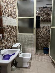 Un baño con lavabo, inodoro y ventana. en Affordable 2bed apartment in Oniru, Victoria Island, en Lagos 2 fotos más