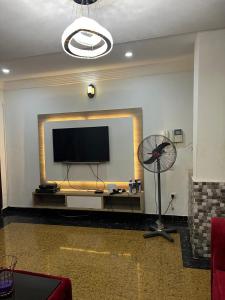 sala de estar con TV de pantalla plana y ventilador en Affordable 2bed apartment in Oniru, Victoria Island, en Lagos