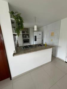 a kitchen with a counter top and a white refrigerator at Lindo apartamento com 2 suites in Rio de Janeiro