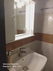 a bathroom with a white sink and a mirror at Giorgos House in Mythimna