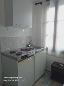 a white kitchen with a sink and a stove at Giorgos House in Mythimna +20 photos