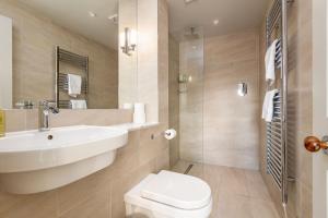 a bathroom with a white sink and a toilet at Gillespie Apartments - Spectacular Penthouse in St. Andrews +37 photos