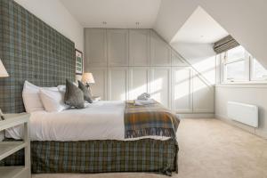 a bedroom with a bed and a large window at Gillespie Apartments - Spectacular Penthouse in St. Andrews