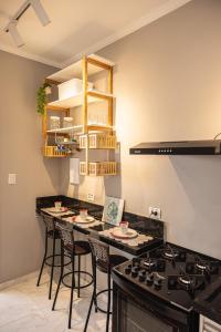 - une cuisine avec un comptoir avec des tabourets et une cuisinière dans l'établissement Studio Edifício Audax lindíssimo pé na areia - Melhor localização de São Vicente, à São Vicente