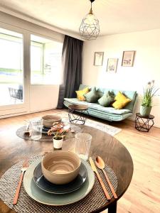 a living room with a table and a couch at Schwarzwald Apartment in Löffingen +10 photos