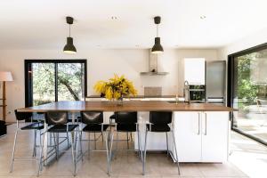 a kitchen with a large kitchen island with stools at Villa cork contis 1 in Lit-et-Mixe