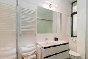 a white bathroom with a sink and a mirror at Vivienda en el Sardinero in Santander +12 photos