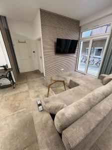 a living room with a couch and a flat screen tv at To&To Apartments Studio in Stuttgart +3 photos