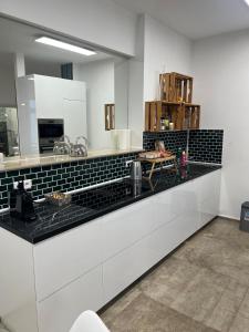 a kitchen with white cabinets and black counter tops at To&To Apartments Studio in Stuttgart