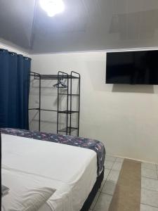 a bedroom with a bed and a tv on a wall at Cabinas Manzanillo Caribe in Manzanillo
