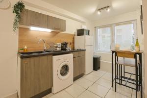 a kitchen with a sink and a washing machine at Le Cocon Urbain-Hyper centre in Saint-Étienne
