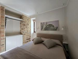 a bedroom with a bed and a brick wall at La Stella del Viandante in Pietrapertosa