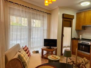 a living room with a couch and a tv and a kitchen at Las Casucas de Remoña in Espinama