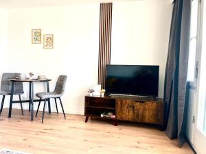 a living room with a television on a wooden entertainment center at Schwarzwald Apartment in Löffingen