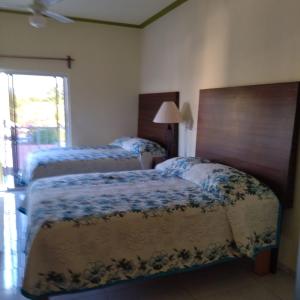 a bedroom with two beds and a window at Casa Quetzal in Peñita de Jaltemba