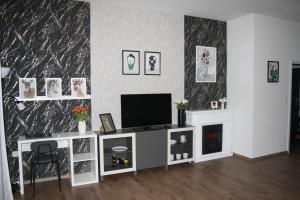 a living room with a television on a white entertainment center at WITH LOVE Marienbad Ap Garden 2 in Mariánské Lázně