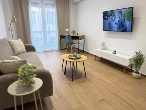 a living room with a couch and a tv on the wall at Athens Pulse in Athens