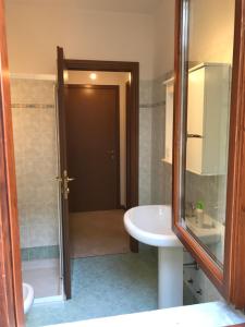 łazienka z umywalką, toaletą i lustrem w obiekcie Costa Verde Apartment w mieście Predore